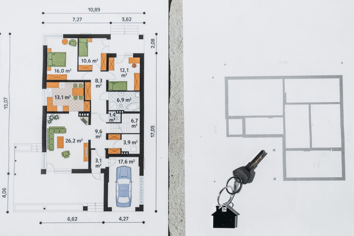 Two printed architectural floor plans with a set of house keys resting on top.