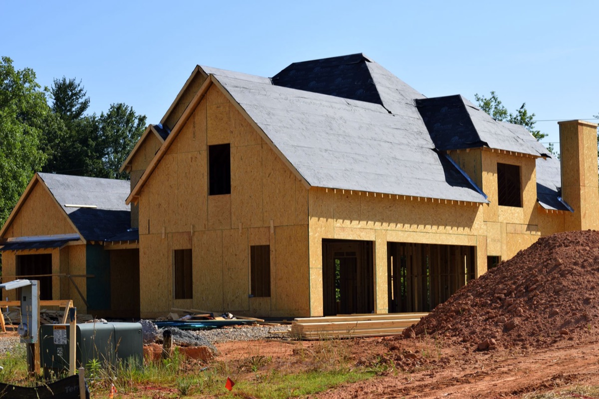 A new two-storey house under construction, framed in lumber on a subdivision lot.