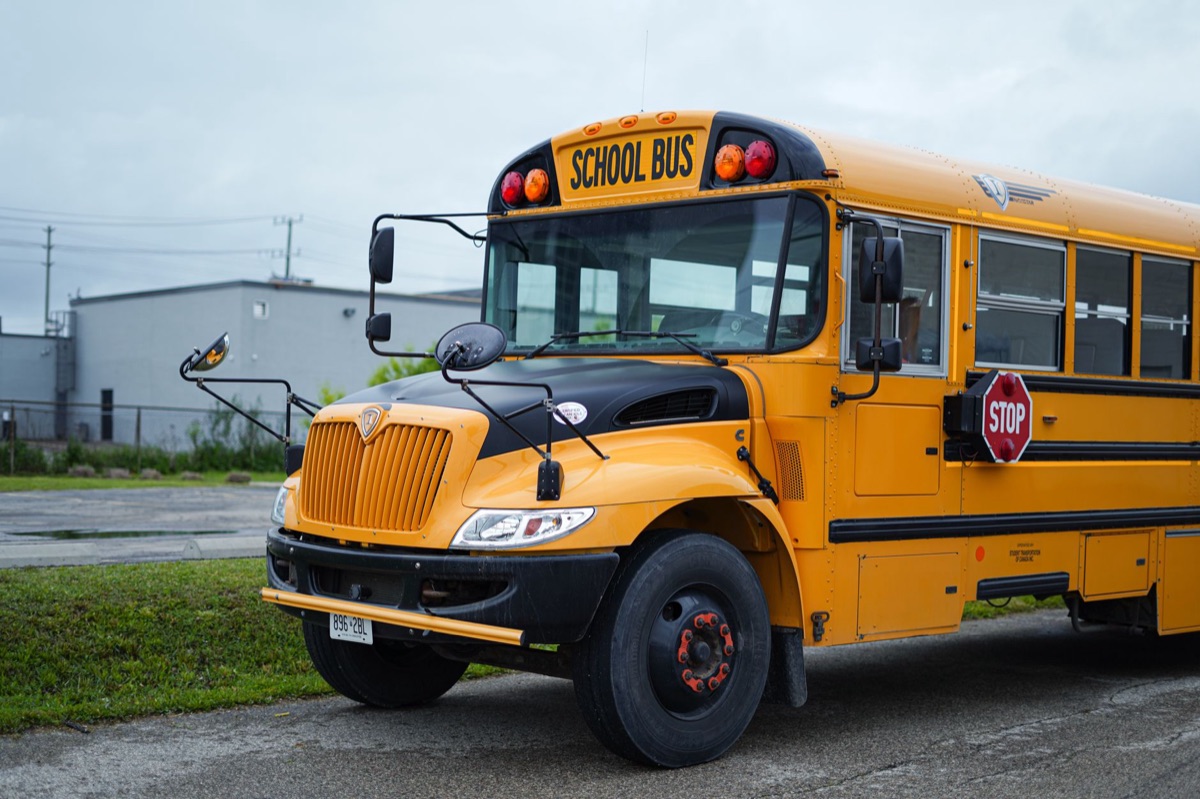 A yellow school bus parked in Kitchener, Ontario, under an overcast sky.